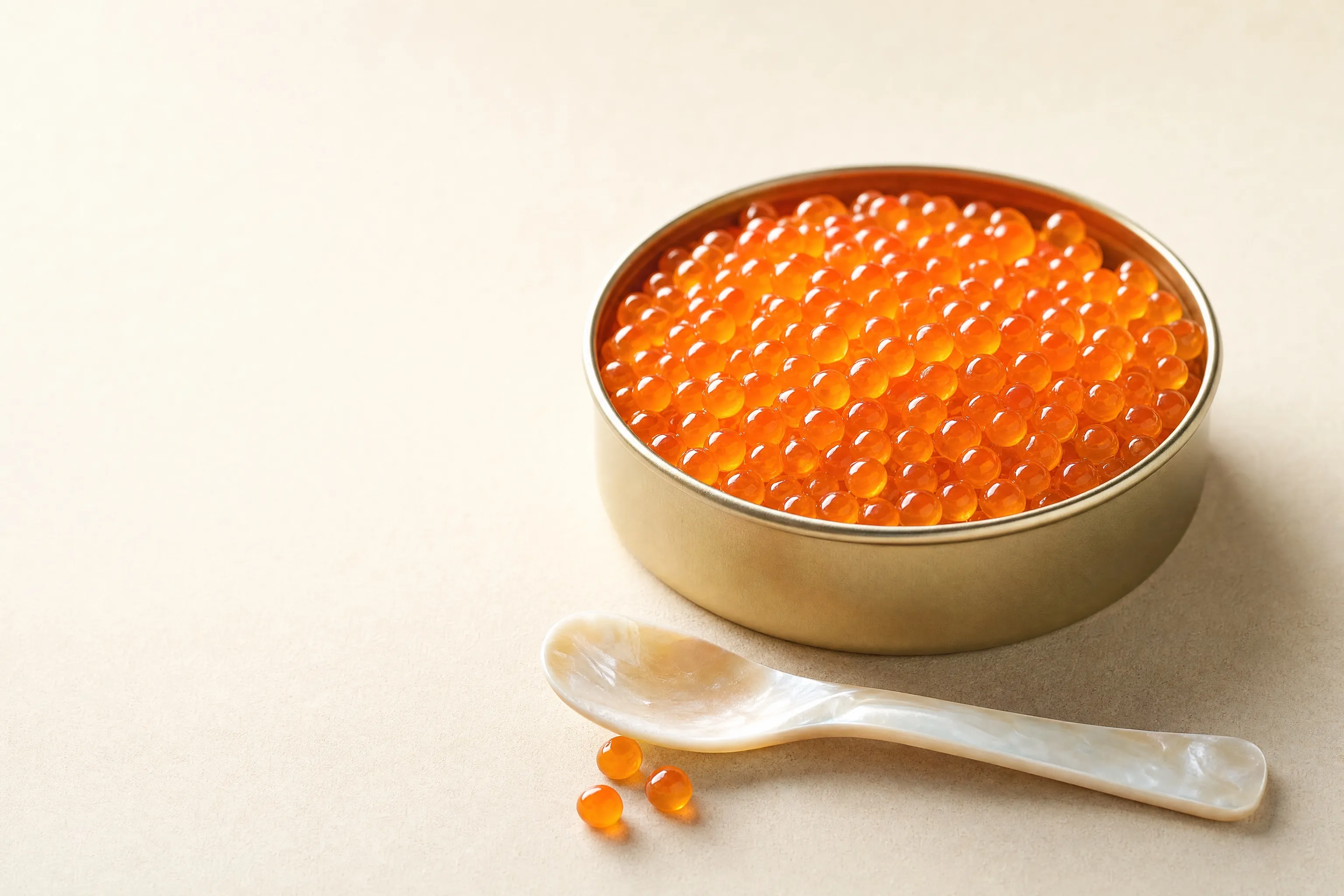 An open tin of Salmon Roe (Ikura) beside the Caviar Kitchen Salmon Roe (Ikura) tin and a mother-of-pearl spoon